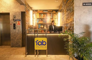 A hotel reception desk with a sign reading "fab HOTELS," a "PRICE WIFI" sign, and a "NO SMOKING" sign. - Fabhotel Clement (Dehradun)