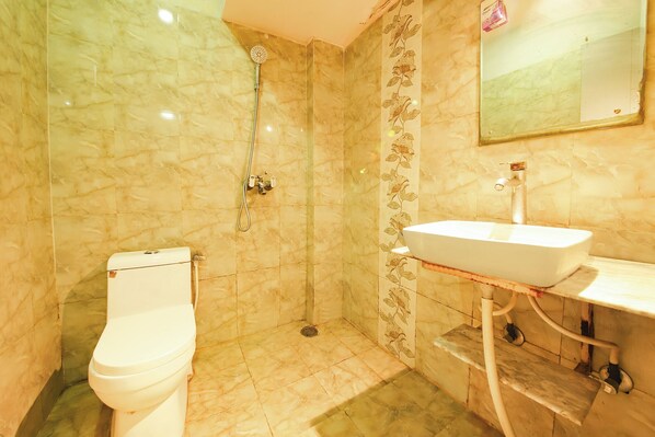 A bathroom with a toilet, a shower, and a sink. - Fabhotel Clement (Dehradun)