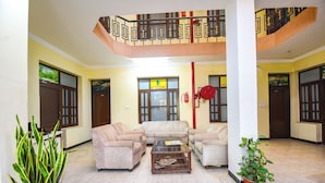 Uma sala de estar ampla com teto alto, escada e vista para o exterior.