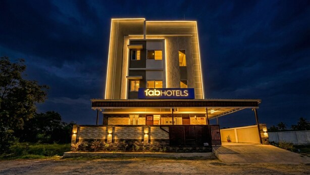 Et moderne hotel med et tydeligt 'fabHOTELS' skilt, der har en ren, geometrisk facade og en godt oplyst indgang.