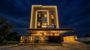 A modern hotel with a prominent 'fabHOTELS' sign, featuring a clean, geometric facade and well-lit entrance. - Via KRV Residency (Coimbatore)