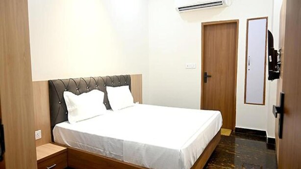 Een slaapkamer met een bed, nachtkastje, kledingkast en een airconditioning.