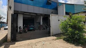 Edifici amb entrada de garatge, una moto i un cotxe aparcats a dins.