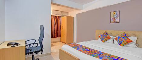 A hotel room with a bed, a desk, and a chair.