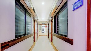 Un couloir propre et bien éclairé, avec un panneau bleu indiquant les numéros des chambres.