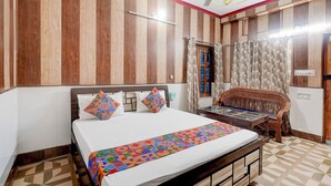 Une chambre à coucher avec un lit, un ventilateur de plafond, une fenêtre avec des rideaux et un panneau mural en bois.