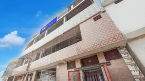 Un hôtel avec une enseigne bleue, plusieurs étages et une façade ornée de motifs.