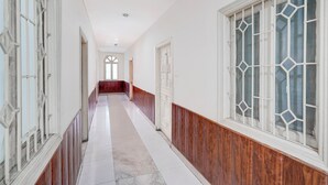 Un long couloir étroit aux murs blancs et au lambris en bois sur la partie inférieure.