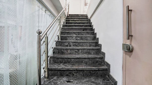 A staircase with metal railings and a door with a handle. - FabHotel Srinidhi Stay Inn - HSR Layout (Bangalore)