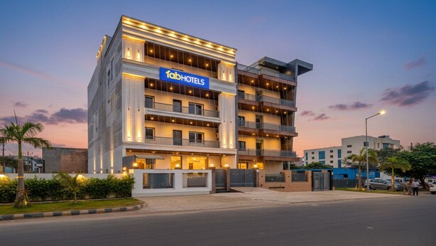 Un hotel de varios pisos con un llamativo letrero de 'fabHOTELS', con balcones y un diseño arquitectónico moderno.