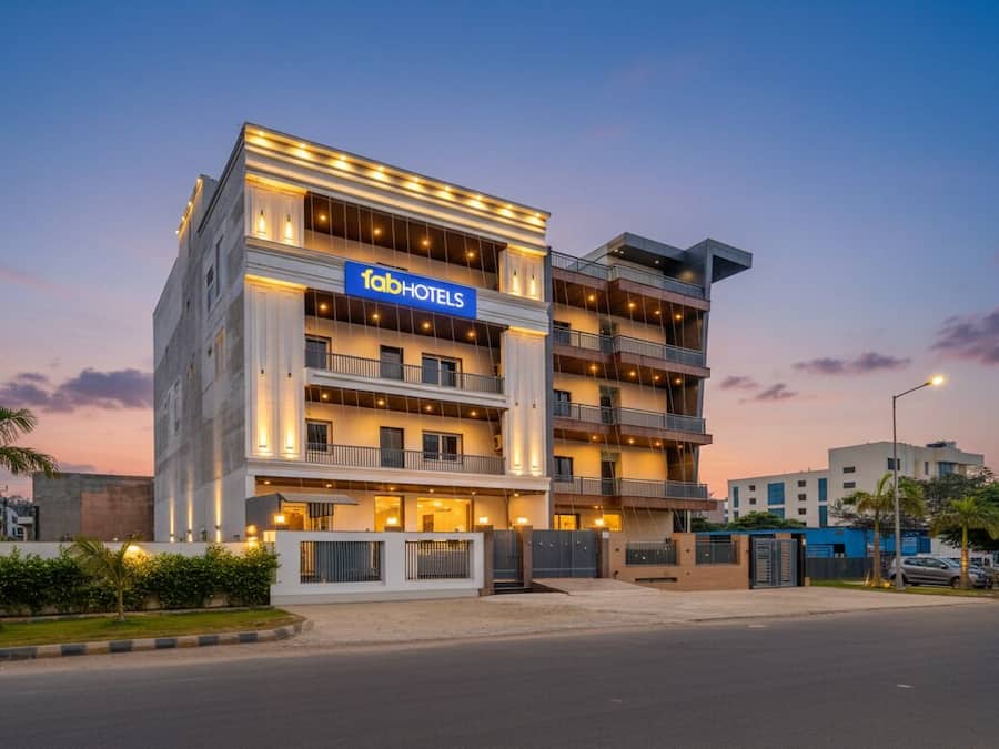 Un hotel de varios pisos con un llamativo letrero de 'fabHOTELS', con balcones y un diseño arquitectónico moderno.