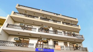 A multi-story hotel building with balconies, air conditioning units, and a sign for 'Tab Hotels'. - Fabhotel Decent (New Delhi)