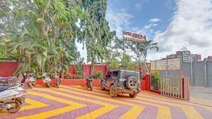 Un aparcamiento con un Jeep y varias motocicletas, un cartel de Hotel Silvery y una entrada con portón.