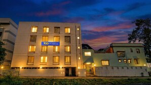 Il s'agit d'un bâtiment moderne, sur lequel on peut voir une enseigne indiquant « Fab Hotels ». Il possède de nombreuses fenêtres et une entrée fermée par un portail.