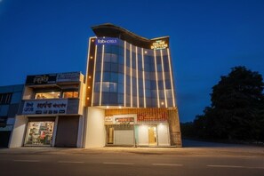 A modern building with a sign for 'fabHOTELS' and 'ONLINE BIRYANI'. - Via Kanak Executive (Pune)
