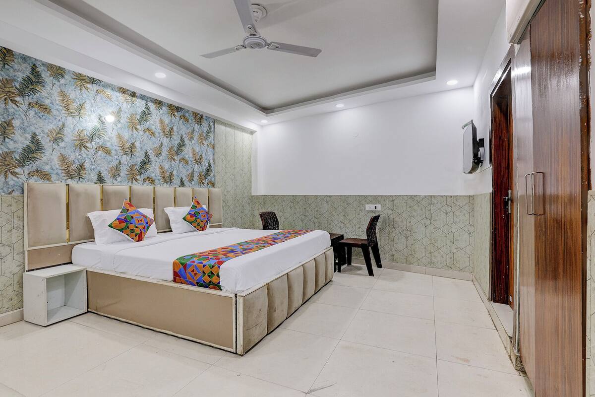 Un dormitorio con una cama, una silla, un escritorio y un armario.