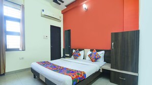 Una habitación de hotel con cama, armario, espejo y aire acondicionado.