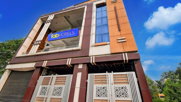 A hotel with a prominent 'fabHOTELS' sign, a modern architectural design, and decorative metal gates at the entrance. - Fabhotel Sunshine Inn (Lucknow)