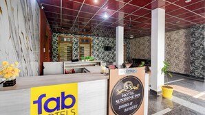 A reception area with a marble wall, a reception desk, and a sign for 'fab hotels'. - Fabhotel Sunshine Inn (Lucknow)