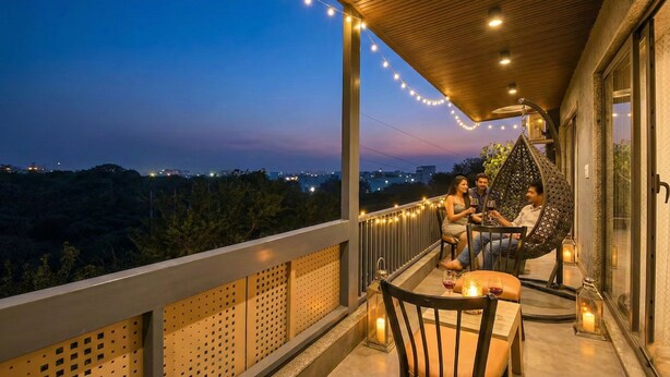 Ein Balkon mit Lichterkette, einem Tisch und Stühlen sowie einem Hängesessel.