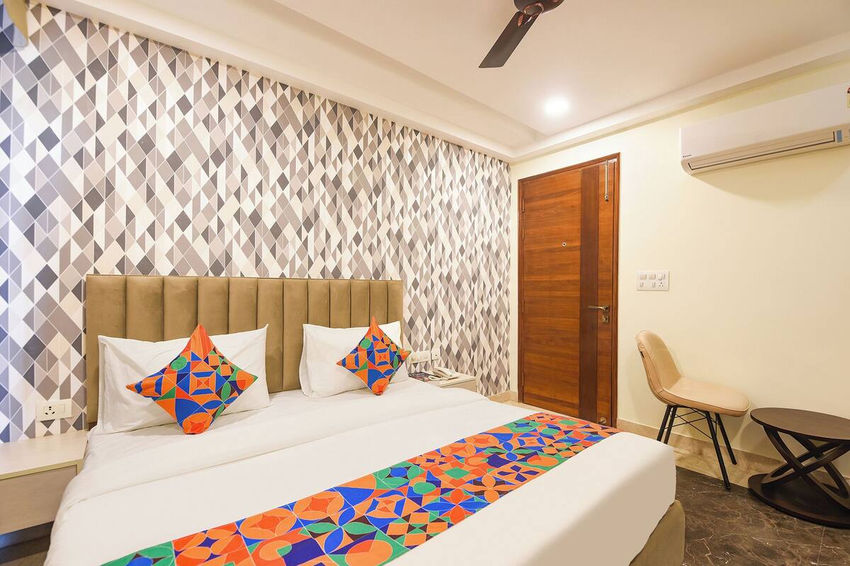 A hotel room with a bed, a chair, and a small table.