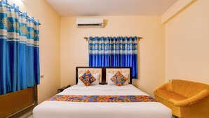 Una habitación de hotel con una cama, una silla y cortinas.