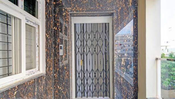 Une porte ornée d’un motif géométrique, une fenêtre à carreaux et un balcon avec une balustrade.