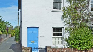 A white building with a blue door, a brick wall, and a small window. - 2 bedroom accommodation in Fordwich, Canterbury (Fordwich, Canterbury)