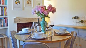 A dining table set with plates, bowls, wine glasses, and a vase with flowers. - 2 bedroom accommodation in Fordwich, Canterbury (Fordwich, Canterbury)