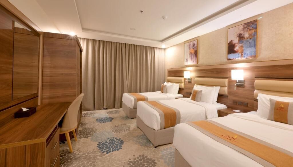 Habitación de hotel con dos camas, un escritorio y una silla.