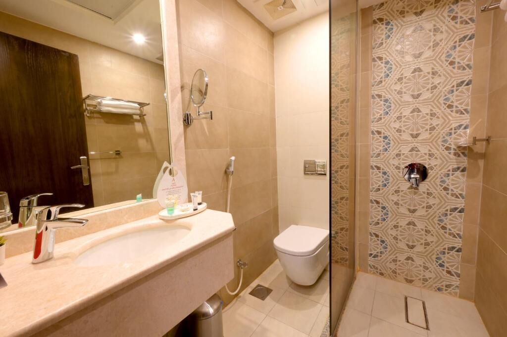 Une salle de bain équipée d’un lavabo, d’un miroir, de toilettes et d’une douche.