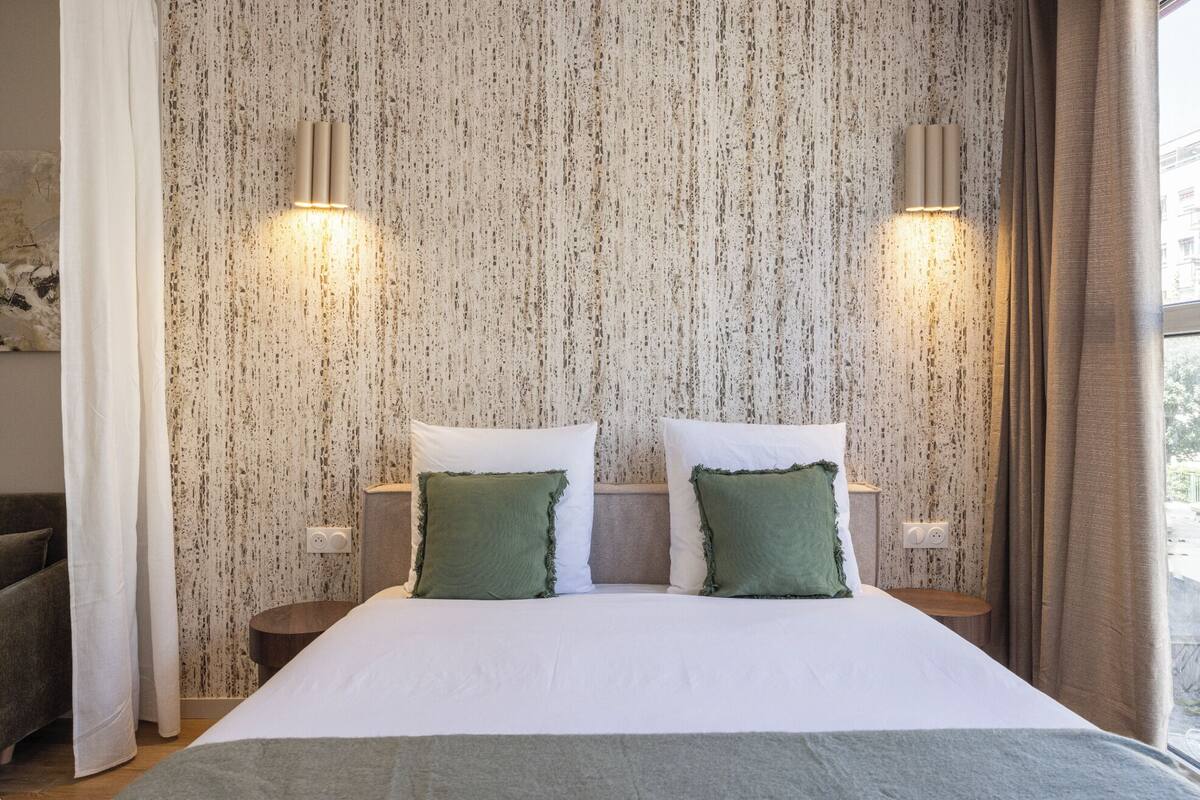 Una camera da letto con un letto, due comodini e un muro con motivo decorativo.