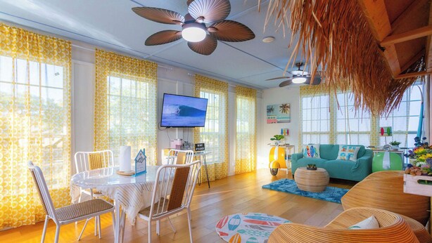 A bright living room with a TV, dining area, and seating. - Jungle Haven, Heated Pool, Fun for 12 (Johnson City)