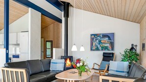 Ein modernes Wohnzimmer mit Kamin, Esstisch und einer Couch.
