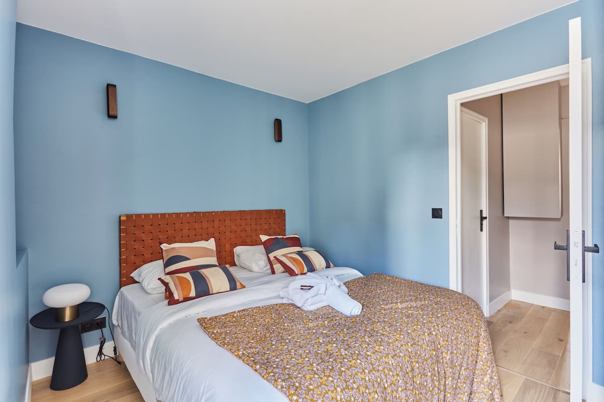 A bedroom with a bed, bedside table, and a wardrobe.