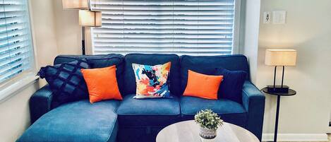 A living room with a sectional sofa, a round coffee table, and a floor lamp.