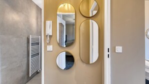 A modern bathroom with a towel rack, a wall-mounted heater, and three mirrors. - Le Cocon 🦋 Apartment in the heart of Thonon les bains ! (Thonon-les-Bains)