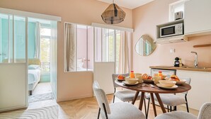 A modern kitchen with a dining area, large windows, and a view of the outside. - Appartements avenue Gourgaud (Paris)
