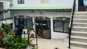 A building with a sign reading 'Bag-Art,' a staircase, and a statue of a person with a basket. - Baz-Art Eco Guest House (Rodrigues Island)