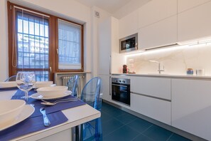 A modern kitchen with white cabinets, a built-in oven, and a microwave. - Ormea Cobalto Apartment by Wonderful Italy (Turin)