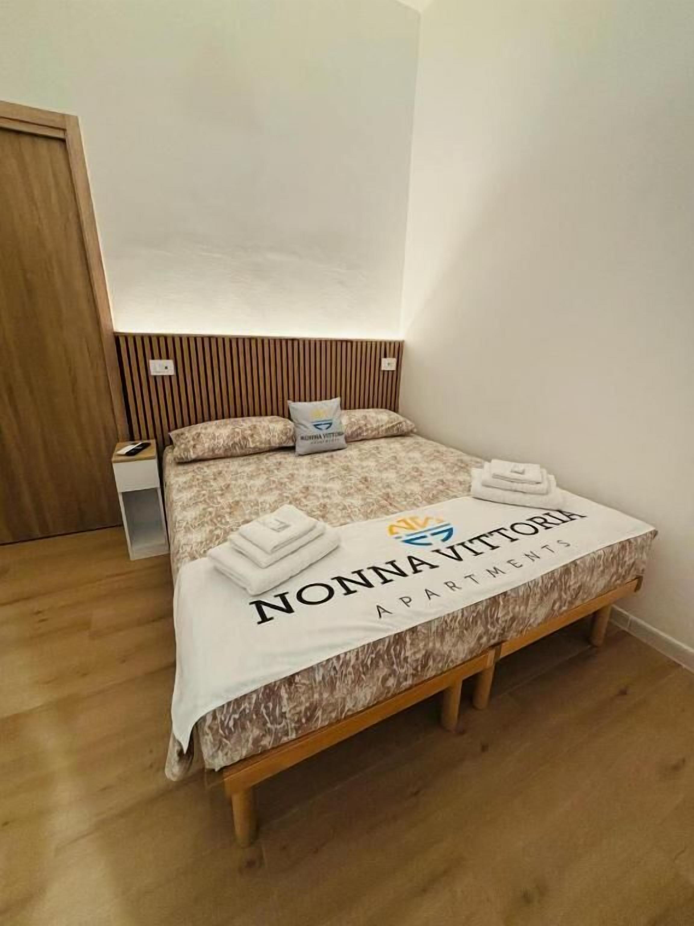 Ein Schlafzimmer mit einem Bett, Kissen, einem Nachttisch und einem hölzernen Kopfteil.