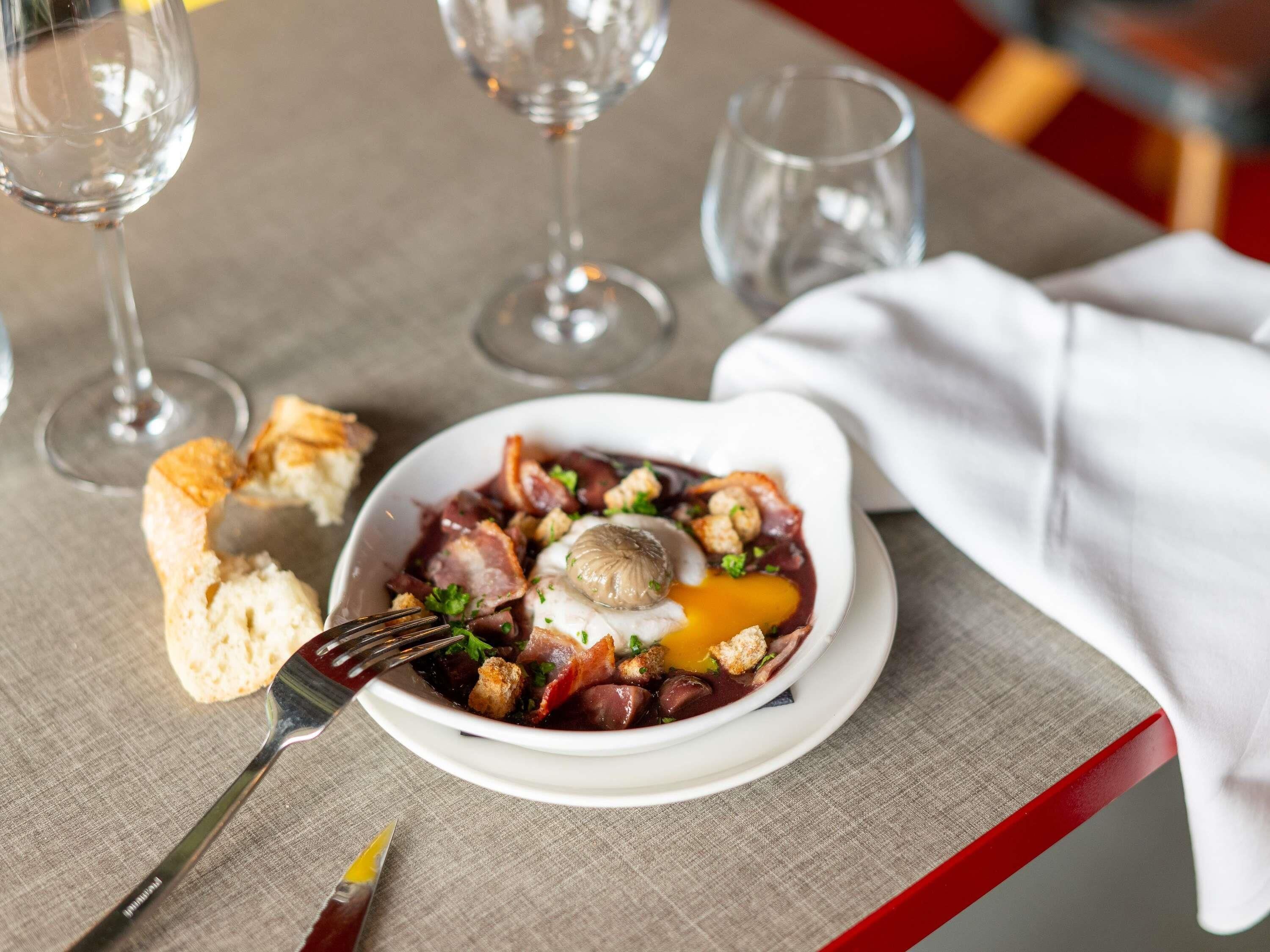 A plate of food with a fork and a napkin on a table.