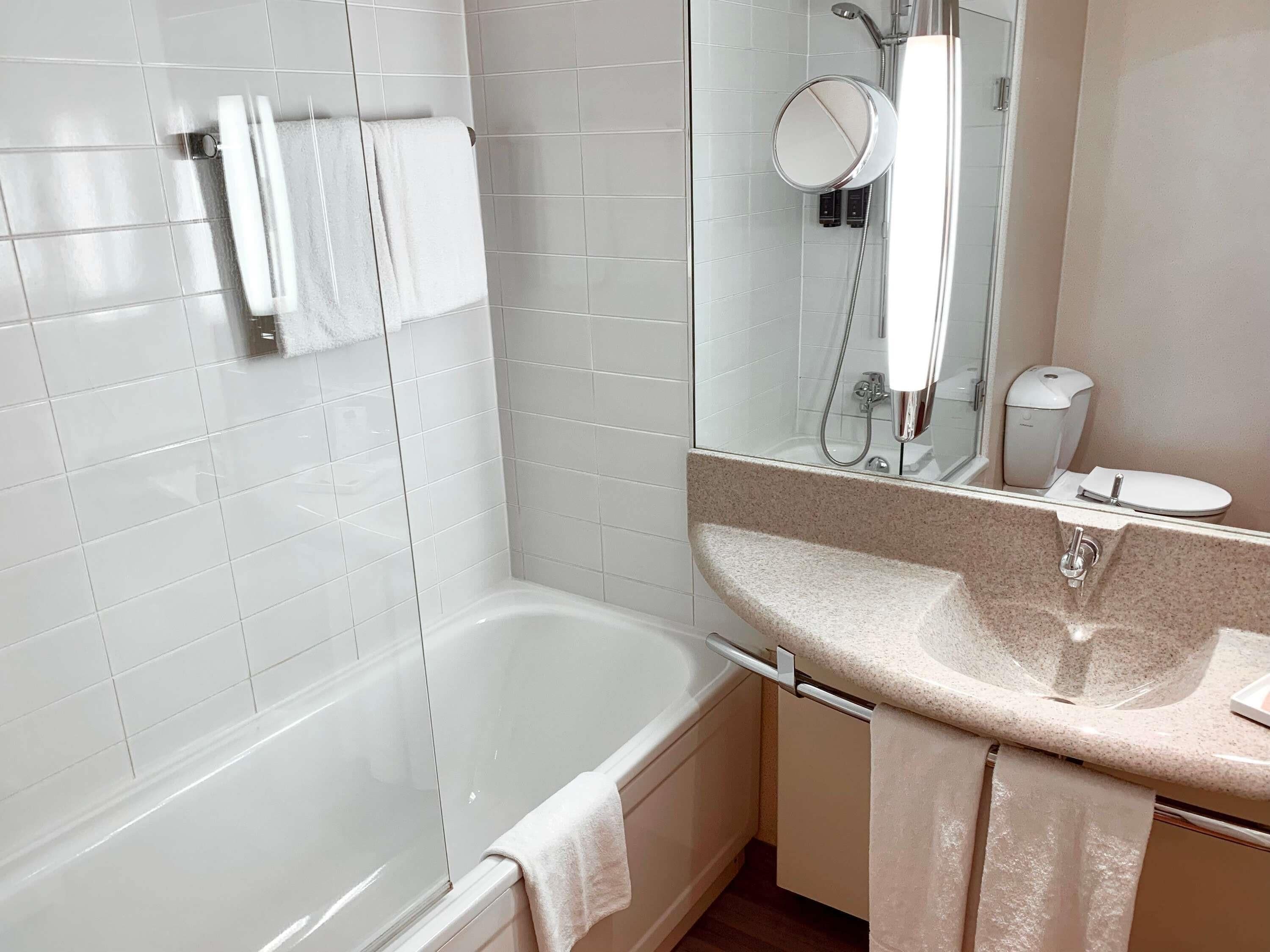 A modern bathroom with a bathtub, a sink, and a mirror.