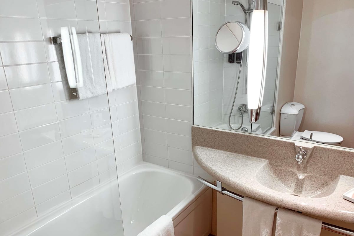 A modern bathroom with a bathtub, a sink, and a mirror.