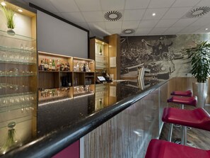 A bar area with shelves of bottles, glasses, and a reflective counter. - Mercure Hotel Hamburg Am Volkspark (Hamburg)