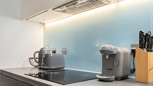 A modern kitchen with an induction cooktop, a coffee maker, and a kettle. - 1-Bed Flat Sleeps 4 · Marble Bath · Walk to Monument & Bank (Greater London)