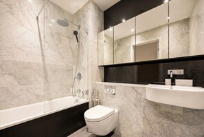 A modern bathroom with a bathtub, toilet, and a sink. - 1-Bed Flat Sleeps 4 · Marble Bath · Walk to Monument & Bank (Greater London)