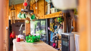 Una cocina con utensilios colgantes, una estufa y una bicicleta al fondo.