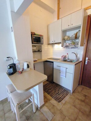 Tweepersoonskamer, uitzicht op zee | Privékeuken | Een microgolfoven, een kookplaat, kookgerei, borden en bestek