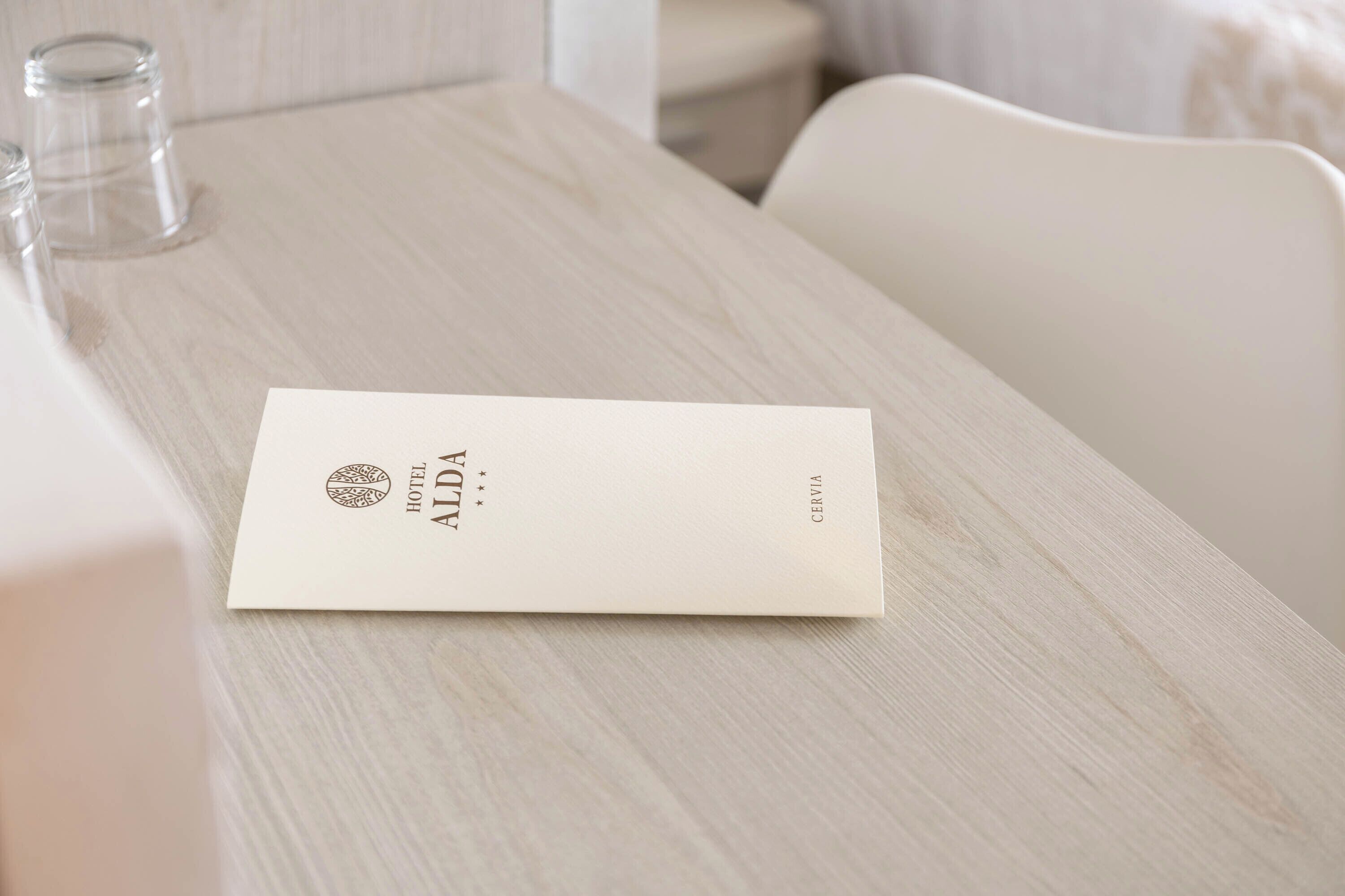 Una habitación de hotel con una mesa de madera, una silla blanca y una cama blanca.